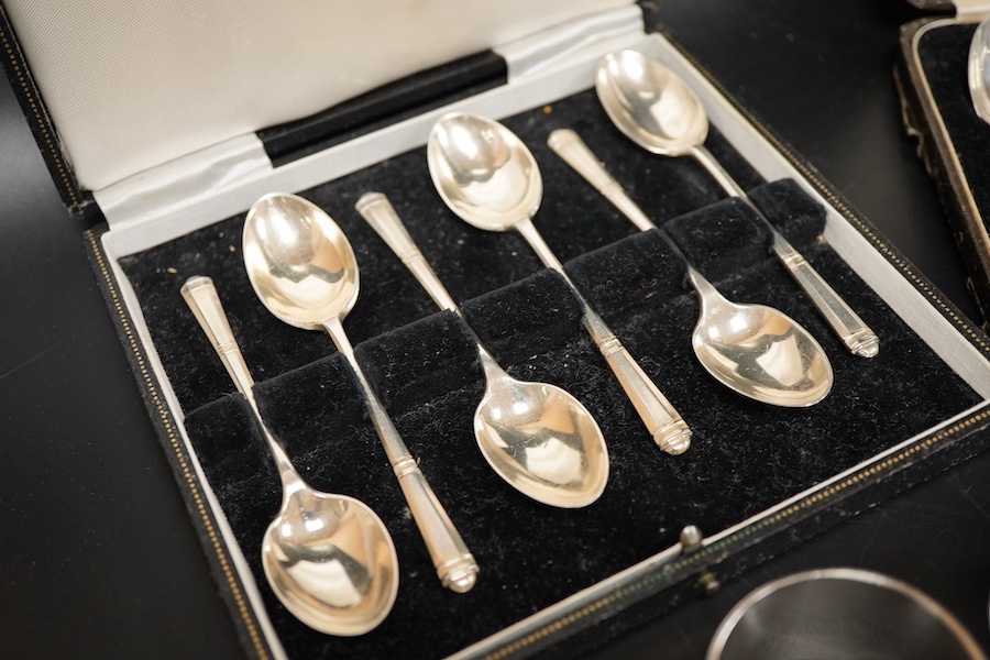 Two cased sets of six mid 20th century silver coffee spoons including Barker Brothers Silver Ltd, Birmingham, 1940, together with a silver and sterling napkin rings and a silver tea strainer on stand.